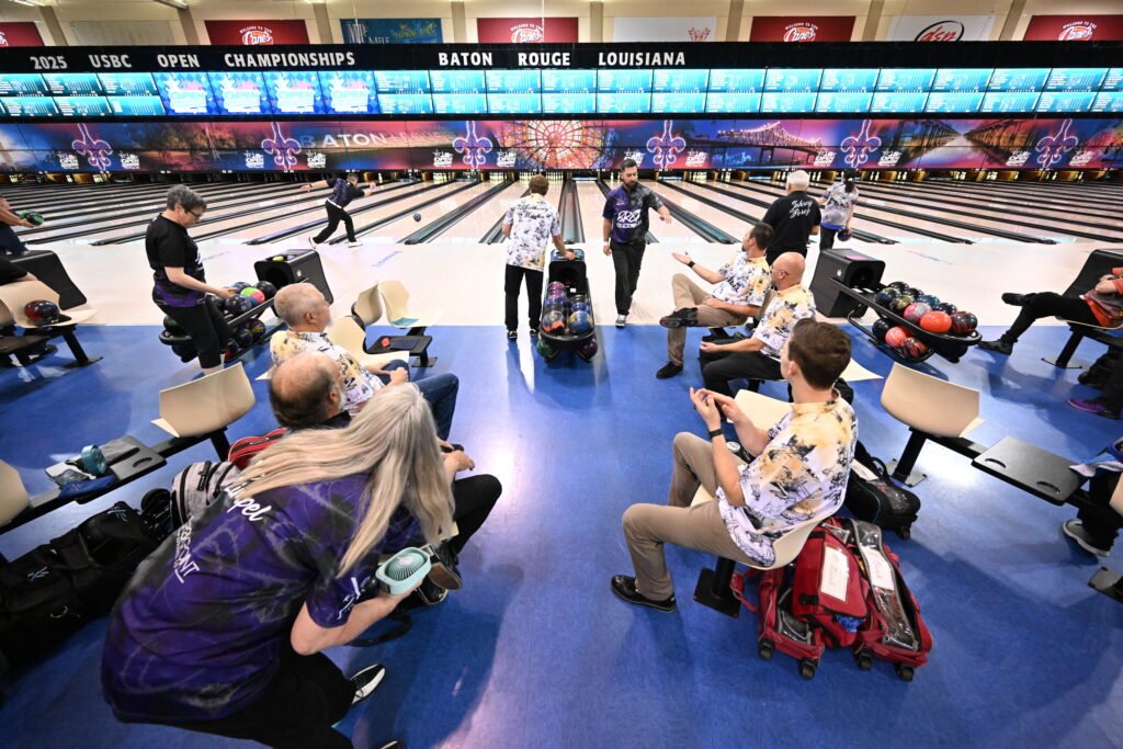 Bowlers in the bowling area of a bowling alley.